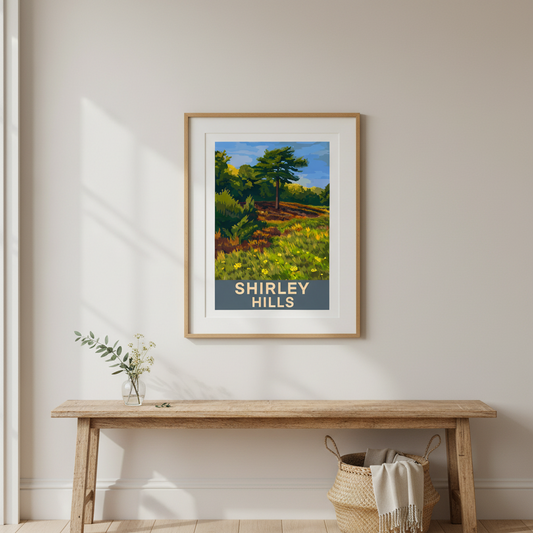Framed retro travel poster art print of Shirley Hills with a wooden bench and decorative items in a room.
